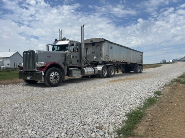 Titan Trucking Peterbilt with aluminum end dump trailer on a gravel road