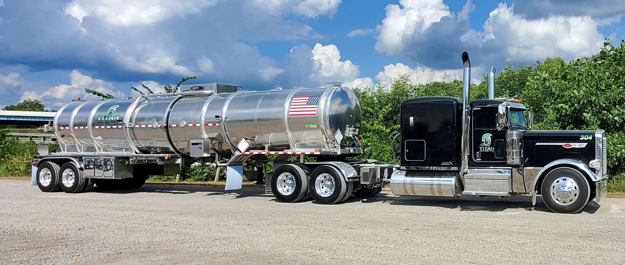 Titan Oil Peterbilt with a polished stainless crude tanker under a blue sky